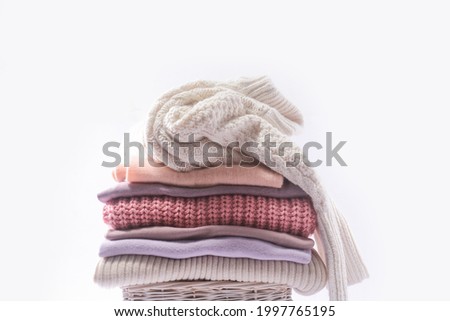 	Stack of different warm sweaters isolated on white background 


