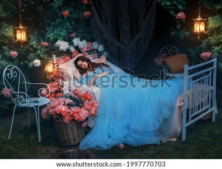 fantasy woman sleeping beauty lies sleep on comfortable bed, mattress, soft pillow. Background mystical garden, night, peonies flowers green trees. Fairy-tale girl princess in blue dress. Sweet dreams Royalty-Free Stock Photo #1997770703