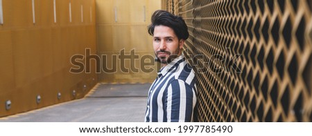 man with mobile and tattoos on golden background