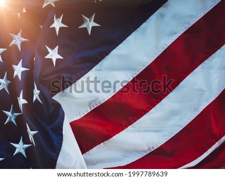 American flag waving in the wind with blue sky with flare light  and is a symbol of peace. military symbols concept. Patriot day