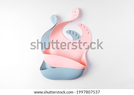 Pink and blue silicone baby bib isolated on white background