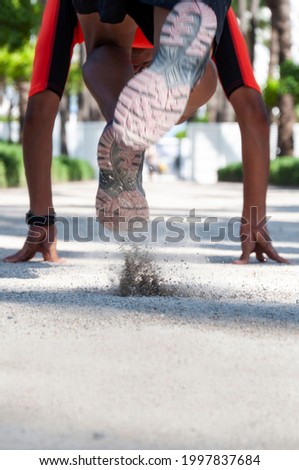 Vertical photo of hispanic runner starting the race on dirt terrain