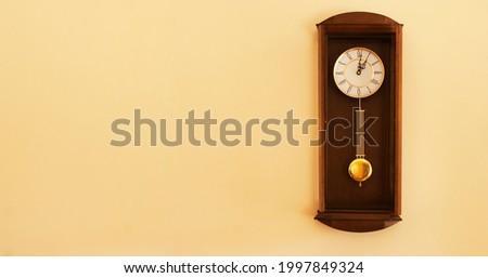 Retro clock on a wall with some copy space for additional content. Royalty-Free Stock Photo #1997849324