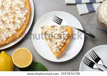 Cut delicious lemon meringue pie served on grey table, flat lay