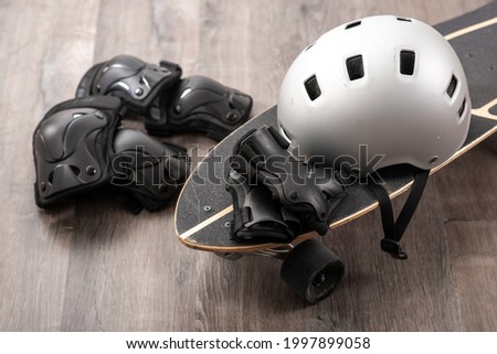 Surfskate and protective gear, helmet, knee pad, elbow pad. Royalty-Free Stock Photo #1997899058