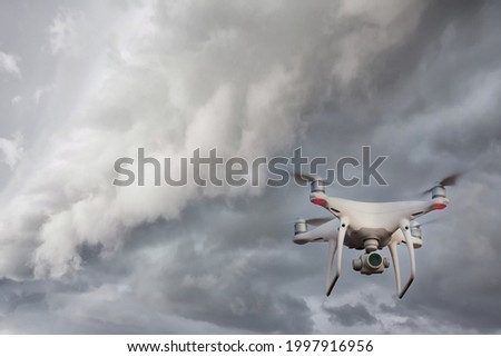 UAV drone copter flying with digital camera. Drone with high resolution digital camera. Flying camera take a photo and video. The drone with professional camera takes pictures of the rain storm on sea