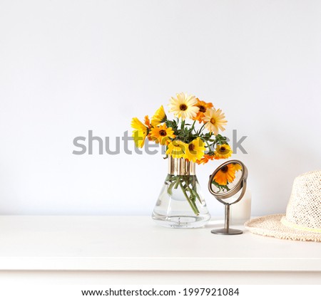 Colorful calendula flowers in a vase on the white table composition. Copy space