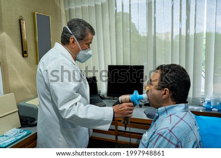 Mature man performing pulmonary function test and spirometry at doctor office Royalty-Free Stock Photo #1997948861