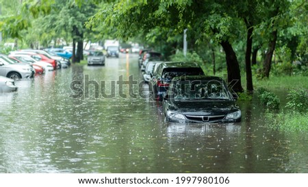 Flooded cars on the street of the city. Street after heavy rain. Water could enter the engine, transmission parts or other places. Disaster Motor Vehicle Insurance Claim Themed. Severe weather concept Royalty-Free Stock Photo #1997980106