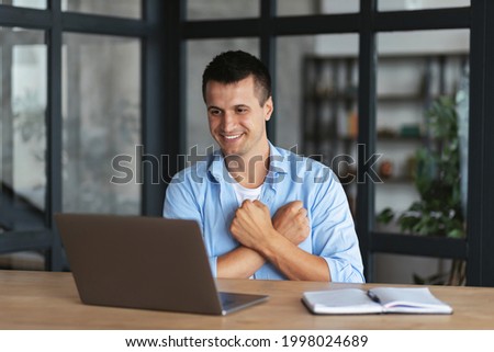 Online communication. Handsome caucasian young male freelancer or student uses sign language while video call using laptop while sitting at home office