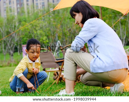 The happy mother and daughter set up a tent outdoors high quality photo