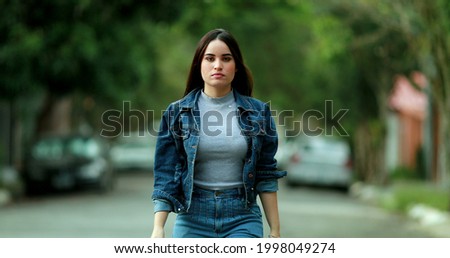 Confident young woman walking forward towards camera portrait