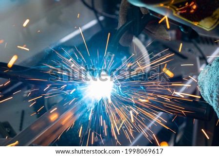close up shot of a man welding pieces of metal togehter