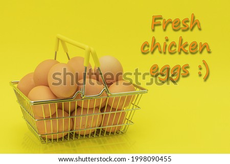 Raw chicken eggs in a basket on a yellow background. Eggs in a metal cart on a yellow background. Background with space for text