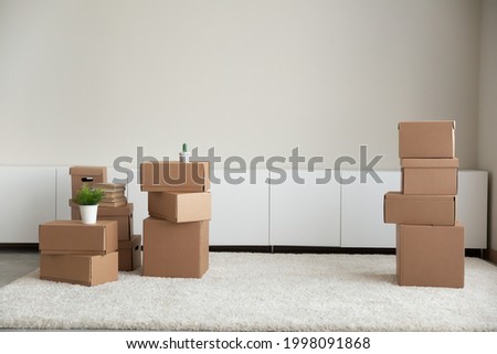 Picture of empty cozy room with cardboard boxes packages in new rent house or apartment. Carton parcels on moving or relocation day settle at home. Real estate, realty, rental concept. Royalty-Free Stock Photo #1998091868