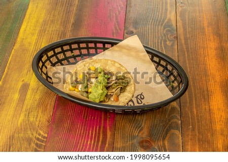 Mexican taco with guacamole, nopales and cooked sweet corn
