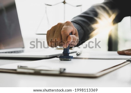 businessman or lawyer put a stamp on business contract in office.