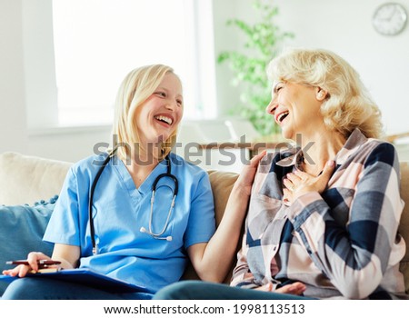 Doctor or nurse caregiver with senior woman at home or nursing home