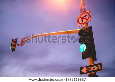 Traffic light and traffic signs on a pole at sunset, Los Angeles, USA