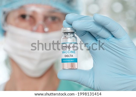 Woman doctor holding a vial with coronavirus Covid19 Delta variant strain vaccine in her hand.