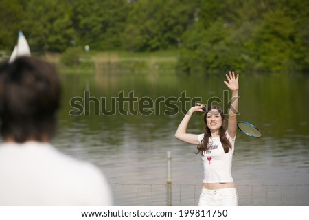 Young couple playing badminton, focus on girl