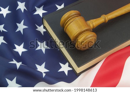 Wooden judge gavel with legal book on USA flag. US court  concept.