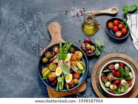 Assorted salads on dark gray background. Seasonal food concept. Top view, flat lay, copy space