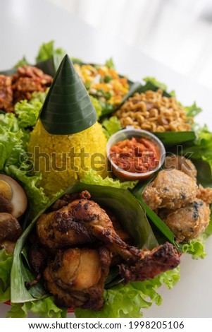 nasi tumpeng. indonesian cuisine yellow rice on banana leaf for celebration Royalty-Free Stock Photo #1998205106