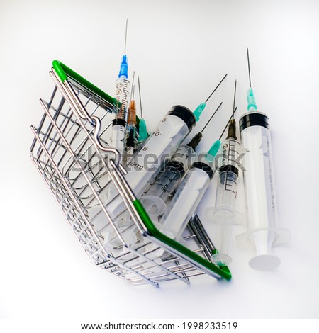 an overturned shopping basket full of medical syringes of various volumes concept vaccination pharmaceuticals. High quality photo