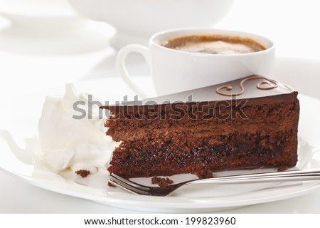 Slice of Sacher cake in plate with coffee Royalty-Free Stock Photo #199823960
