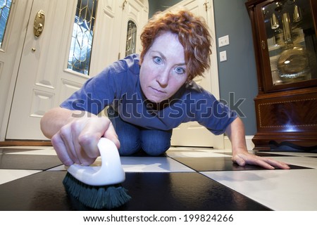 Close up view of a woman scrubbing the floors on her hands and knees. Royalty-Free Stock Photo #199824266
