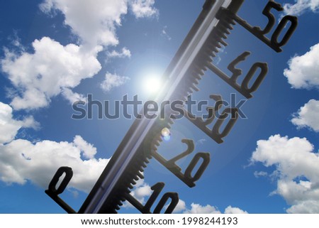 Symbol image: Thermometer in front of blue sky shows warm temperatures