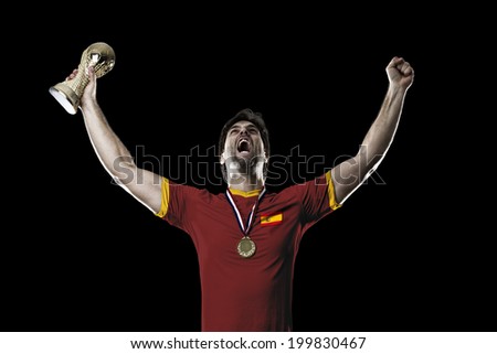 Spanish soccer player, celebrating the championship with a trophy in his hand. On a black background.