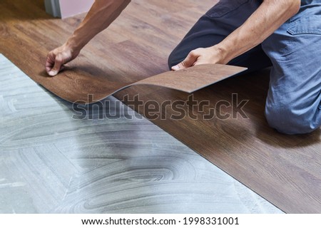 worker joining vinyl floor covering at home renovation Royalty-Free Stock Photo #1998331001