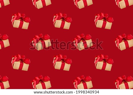 Seamless pattern with wrapped gift box with festive ribbon on red background. Holiday concept