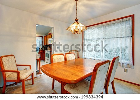 Cozy bright dining room with wooden table and comfortable chairs.