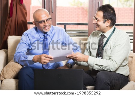 Business man having meeting at home with an insurance agent  Royalty-Free Stock Photo #1998355292