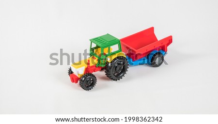 Plastic toy multicolored cars isolated on white background. Tractor with a trailer.