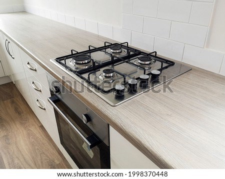 Kitchen counter with newly installed cooker with gas hob burners. Newly renovated house ready for sale or rental on the UK market. Royalty-Free Stock Photo #1998370448
