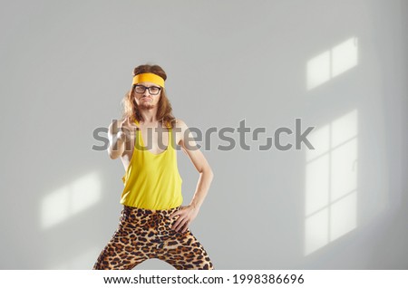 I choose you. Goofy fit yoga or gym fitness workout trainer in glasses, yellow sports headband, tank top and funny leopard print leggings pointing finger at camera with serious angry face expression