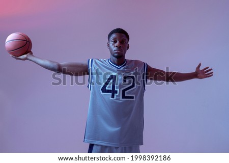 Athletic basketball player with ball in studio