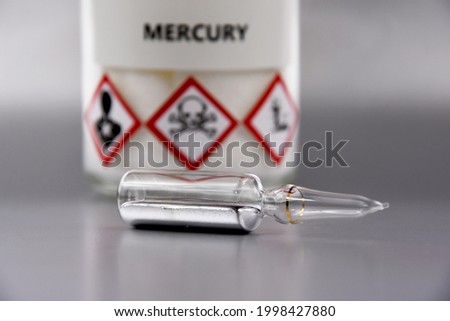 Mercury chemical element stock images. Laboratory accessories images. Mercury in a sealed ampoule stock photo. Laboratory equipment on a silver background. Hg, toxic chemical element stock images Royalty-Free Stock Photo #1998427880