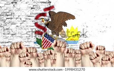 Raised fists of men against the background of the flag of State of Illinois painted on the wall, the concept of popular unity and the opinion of the majority.