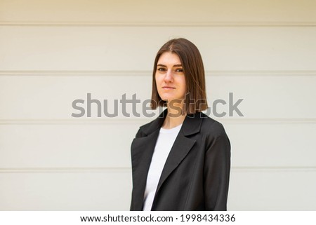 Business woman portrait outdoors. A young girl in business clothes poses for a photo session for resume.