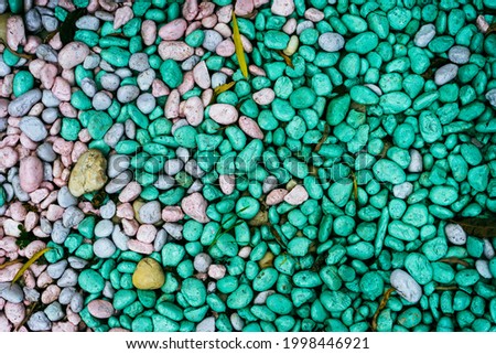 natural colorful small rocks background, green pink and gray colors