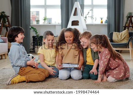Group of little kids with digital tablet watching online cartoons