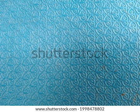 The blue plastic surface has an unusual pattern use for a background