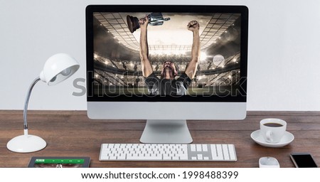 Composition of male rugby player holding cup at rugby stadium on computer. sport and competition concept digitally generated image.