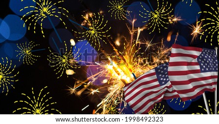 Composition of sparklers and spot lights over american flags. patriotism, independence and celebration concept digitally generated image.