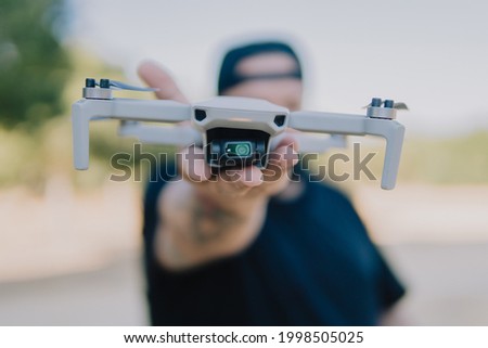 A shallow focus shot of a male holding a drone outdoors